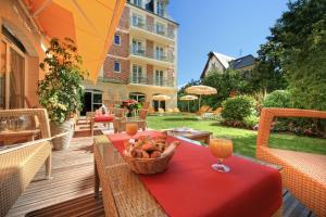 a table with a basket of bread and a glass of orange juice at La Closerie SPA & Résidence Hôtel in Deauville