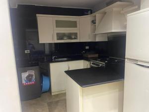 eine Küche mit weißen Schränken und einer Arbeitsplatte in der Unterkunft Leila Home Garden - Maamourah Beach in Alexandria + 6 Fotos