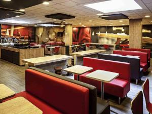 a restaurant with red chairs and tables in a restaurant at ibis Copacabana Posto 5 in Rio de Janeiro