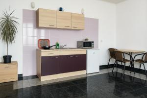 a kitchen with a sink and a microwave and a table at Apartman Tia in Osijek