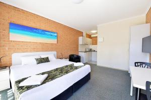 a hotel room with a bed and a desk at Cranbourne Motor Inn in Cranbourne