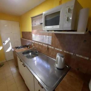 a small kitchen with a sink and a microwave at El Calafate in El Calafate