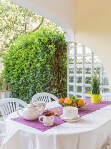 uma mesa branca com chávenas de chá e laranjas em Apartamento Esmeralda VyB em Denia