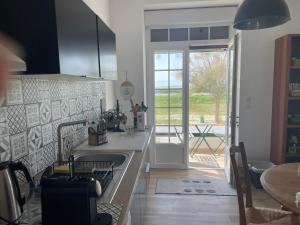 a kitchen with a sink and a counter top at La maison sur la plage in Marennes