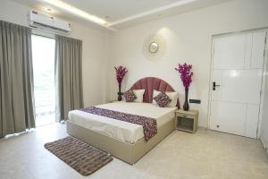 ジャイプールにある6BHK Villa with pool Near Jaipur Junctionの大きなベッドと大きな窓のある寝室