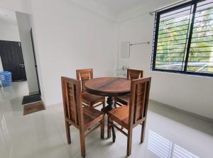 a wooden table and chairs in a room with a window at Harmony Residence in Trivandrum +16 photos