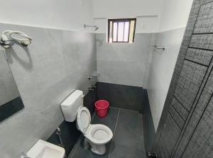 Un baño pequeño con inodoro y lavabo. en Harmony Residence, en Trivandrum