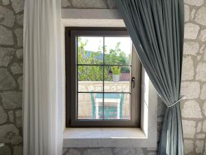 a window in a brick wall with a curtain at TaşAda Bozcaada in Bozcaada