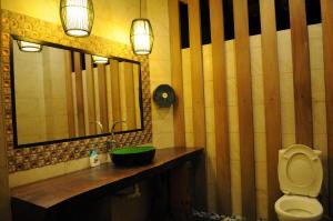 a bathroom with a sink and a mirror and a toilet at Marina Oriental Hotel in Butterworth