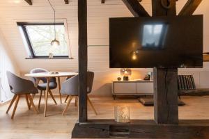 a living room with a tv and a table at Lütt Heidjer Hus in Buchholz in der Nordheide