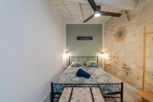 una camera da letto con un letto in una stanza con un muro di pietra di Immeuble 3 Apparts Centre historique St Gilles MaisoncarreeConciergerie a Saint-Gilles