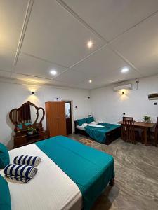 a bedroom with two beds and a desk and a table at New mahi mahi villa in Dickwella