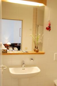 a white bathroom with a sink and a window at Altstadt Hotel Meppen in Meppen