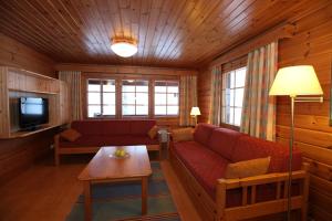 a living room with a red couch and a tv at Hapimag Ferienwohnungen Punkaharju in Punkaharju