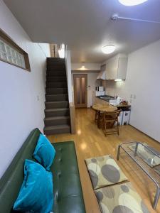 a living room with a green couch and a kitchen at About a 3minute walk from JR Nishi-Ogikubo St, in Kichijōji
