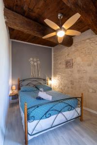 una camera con letto e ventilatore a soffitto di Immeuble 3 Apparts Centre historique St Gilles MaisoncarreeConciergerie a Saint-Gilles