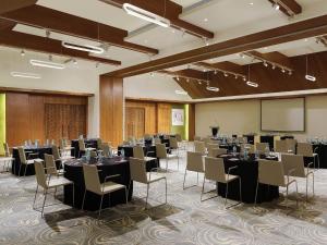 a conference room with tables and chairs and a screen at ibis Styles Goa Calangute - An Accor Brand in Calangute +97 photos