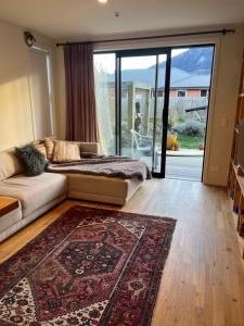 a living room with a couch and a rug at Lake Hawea Little Maude Snug in Lake Hawea