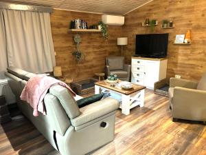 a living room with a couch and a tv at Het Zenhuisje in Lanaken