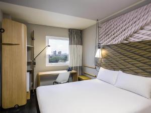 a hotel room with a large bed and a window at ibis Fortaleza Centro de Eventos in Fortaleza
