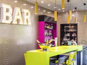 Un bar con un mostrador amarillo y sillas amarillas. en ibis Styles Antony Paris Sud, en Antony