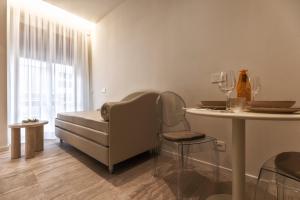 a living room with a couch and a table with chairs at Valentino Rooms in Ravenna