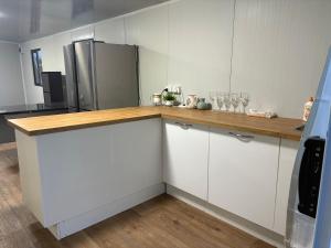 KumeuにあるEasy homeの白いキャビネットと冷蔵庫のあるキッチン +1枚の写真