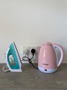 a pink appliance plugged into an outlet in a wall at Little J villa in Dickwella