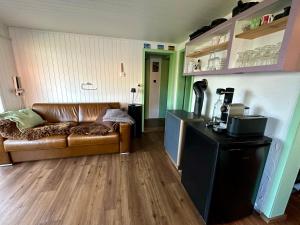 a living room with a brown couch and a table at Chalet Tännli - CharmingStay in Flumserberg