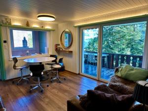 a living room with a table and chairs and a balcony at Chalet Tännli - CharmingStay in Flumserberg