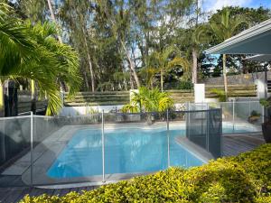 a swimming pool with a fence around it at Villa Sunniva in Mahébourg