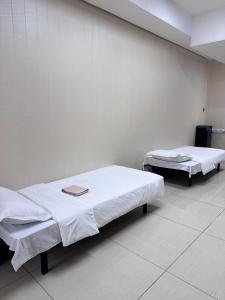 two beds in a hospital room with white walls at UB NEST-guest house in Ulaanbaatar