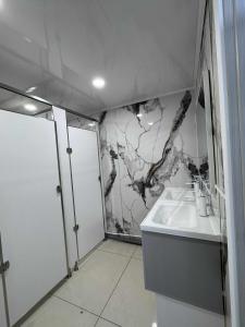 a bathroom with a sink and a marble wall at UB NEST-guest house in Ulaanbaatar