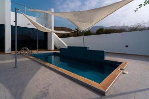 a swimming pool with a hammock on a house at Camilla Chalet in Muhya