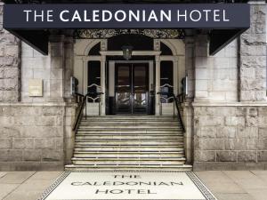 a sign for the caledonian hotel in front of a building at Mercure Aberdeen Caledonian Hotel in Aberdeen