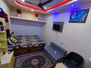 a small room with a bed and a tv in it at RS Homestay Puri in Puri