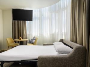 Habitación con cama, silla y ventana en Ibis Styles Lisboa Centro Liberdade NE, en Lisboa