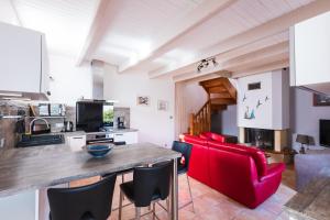 a kitchen with a wooden table and red chairs at Ty Ker'embruns, charmant penty au cœur de L'Armor Pleubian in Pleubian