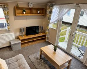 a living room with a couch and a television at 59 the cedarS in Winthorpe