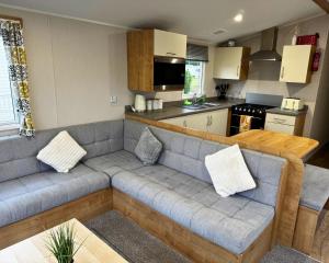 a living room with a couch and a kitchen at 59 the cedarS in Winthorpe