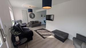 ein Wohnzimmer mit einer Couch und einem Sessel in der Unterkunft Modern Gilliver House Rural retreat sleeps 7 in Barlestone