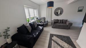 ein Wohnzimmer mit einer Couch und einem Sessel in der Unterkunft Modern Gilliver House Rural retreat sleeps 7 in Barlestone