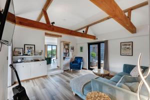 a living room with a couch and a table at Seven Space - Willow Barn, Hot Tub & Scenic Rural Retreat in Haddiscoe