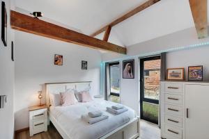 a bedroom with a bed and a window at Seven Space - Willow Barn, Hot Tub & Scenic Rural Retreat in Haddiscoe +25 photos