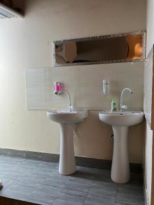 サラーラにあるyouth Hostelの洗面台が2つと鏡があるバスルーム
