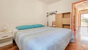 a bedroom with a bed with blue pillows on it at Mesic in Novigrad Istria