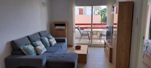 a living room with a blue couch and a table at El Soleado El Rincon in Campoamor