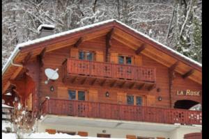 a large wooden house with a balcony in the snow at Chalet La Rose in Montriond