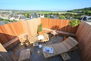 a patio with a table and chairs and a fence at La Closerie SPA & Résidence Hôtel in Deauville