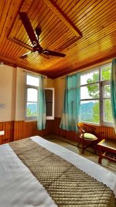 a bedroom with a bed and a ceiling fan at The Pahadi Ghar in Chail